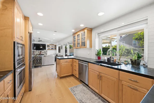 a kitchen with stainless steel appliances a stove sink microwave refrigerator and cabinets