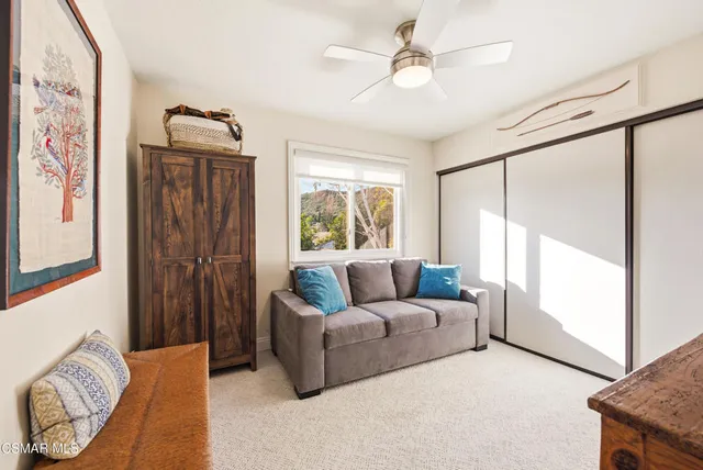 a spacious bedroom with a bed a chandelier and a flat tv screen