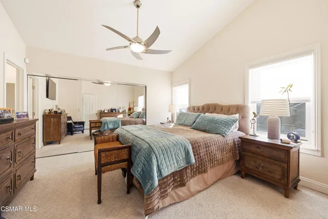 a bedroom with a bed a couch and a chandelier