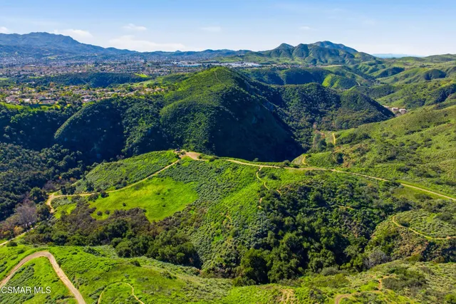 an aerial view of a house with a yard pool a patio and mountain view