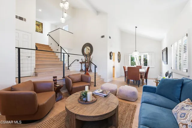 a dining room with wooden floor a chandelier a wooden table and chairs