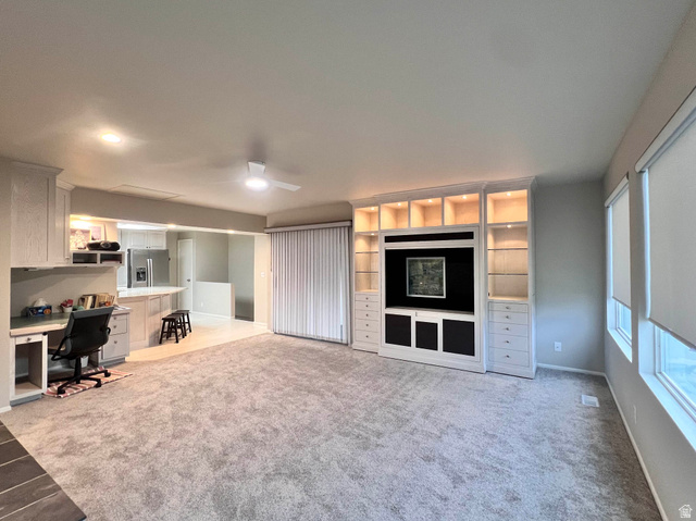 8097 South 535 East Sandy, UT 84070 - Photo 5 of 15 Spacious living area featuring light gray carpeting and a ceiling fan