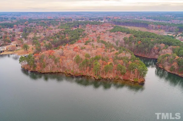 an aerial view of residential houses with outdoor space and lake view