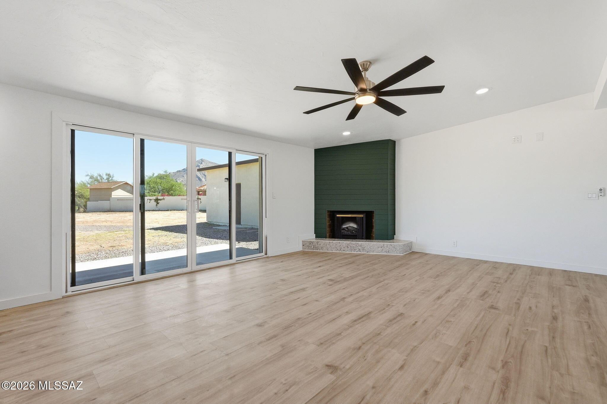 950 West Ina Road Tucson, AZ 85704 - Photo 4 of 54 an empty room with wooden floor fan and windows