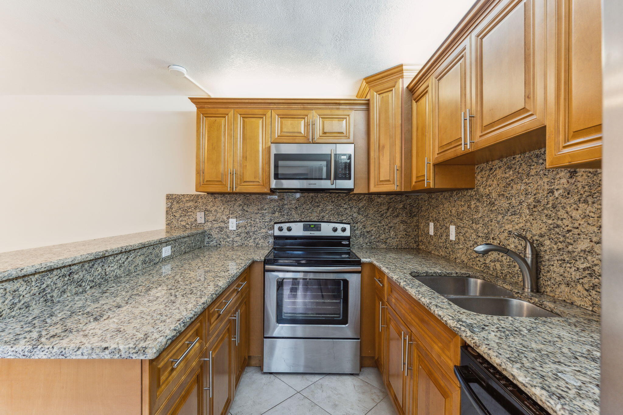 2438 Waterside Drive Lake Worth, FL 33461 - Photo 12 of 26 a kitchen with granite countertop a sink and a stove