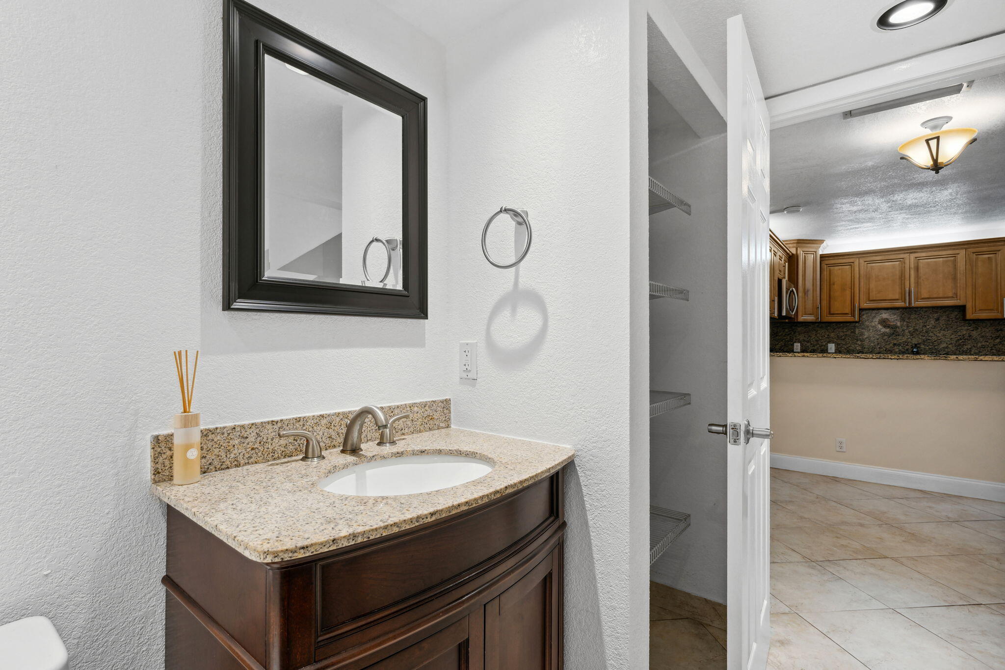 2438 Waterside Drive Lake Worth, FL 33461 - Photo 14 of 26 a bathroom with a granite countertop sink a mirror and a vanity