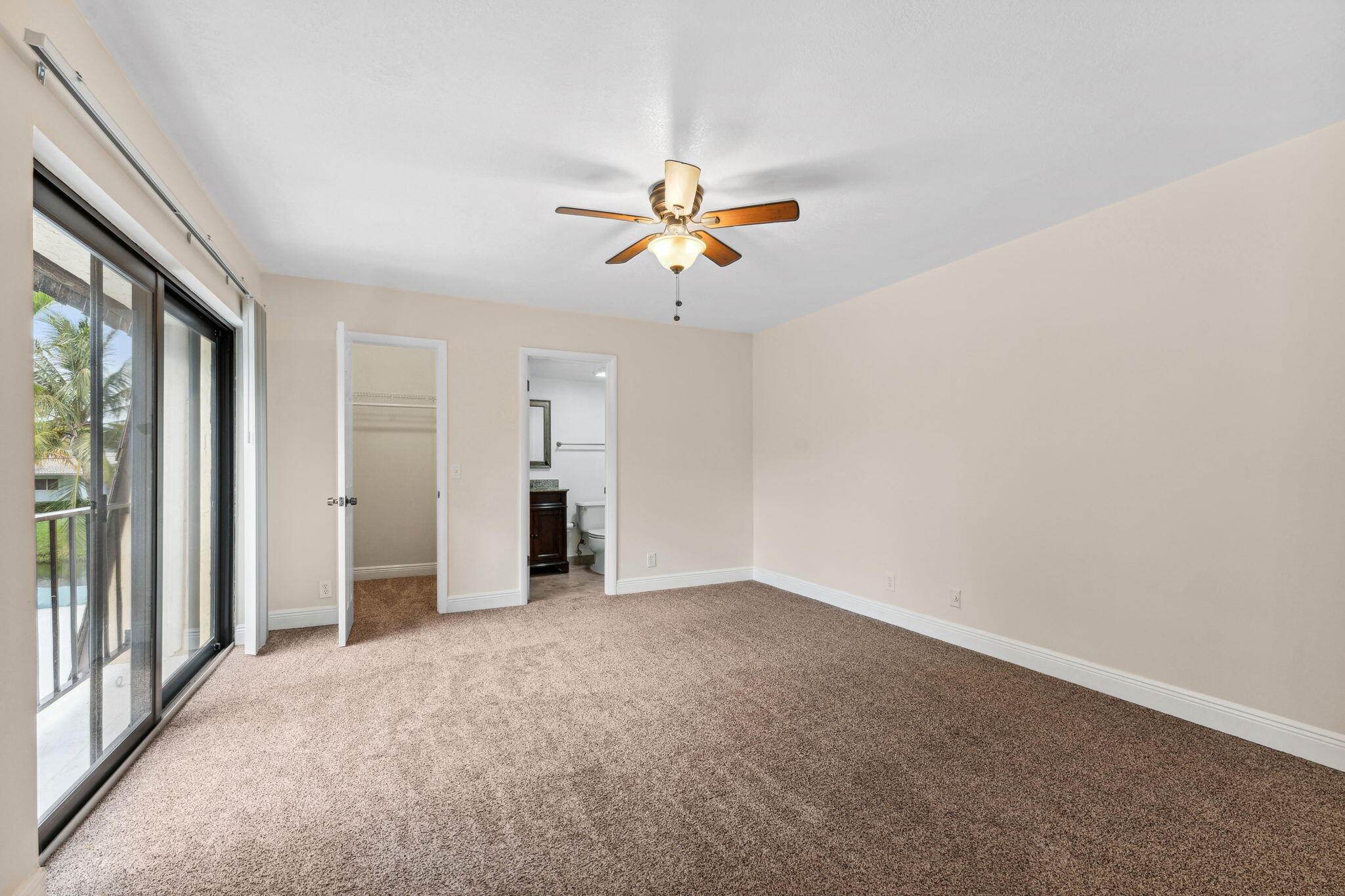 2438 Waterside Drive Lake Worth, FL 33461 - Photo 16 of 26 an empty room with chandelier fan and windows