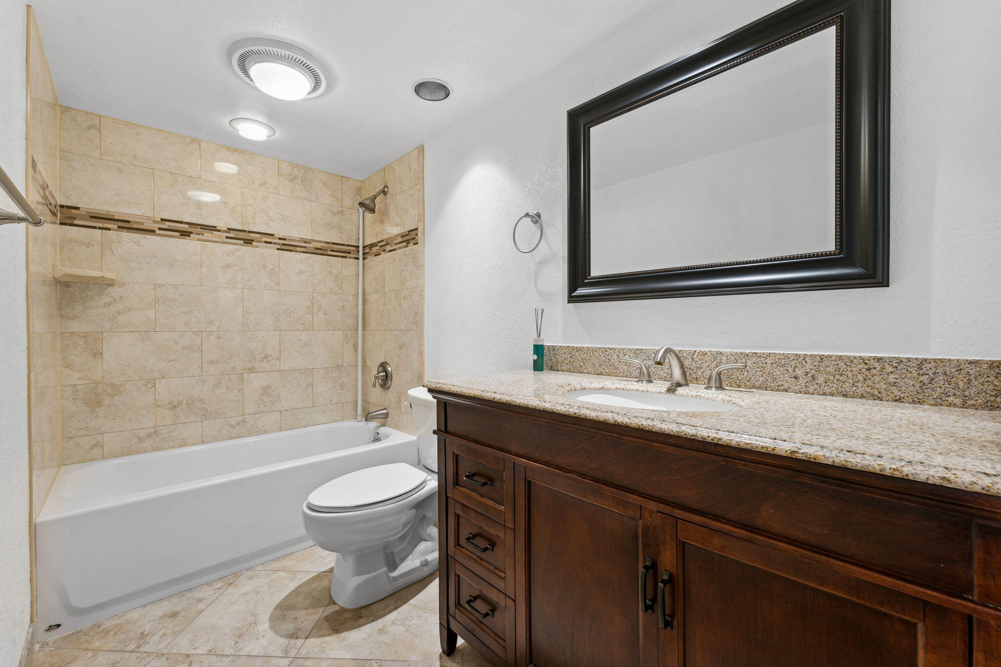 2438 Waterside Drive Lake Worth, FL 33461 - Photo 21 of 26 a bathroom with a granite countertop sink toilet a large mirror a bathtub and shower