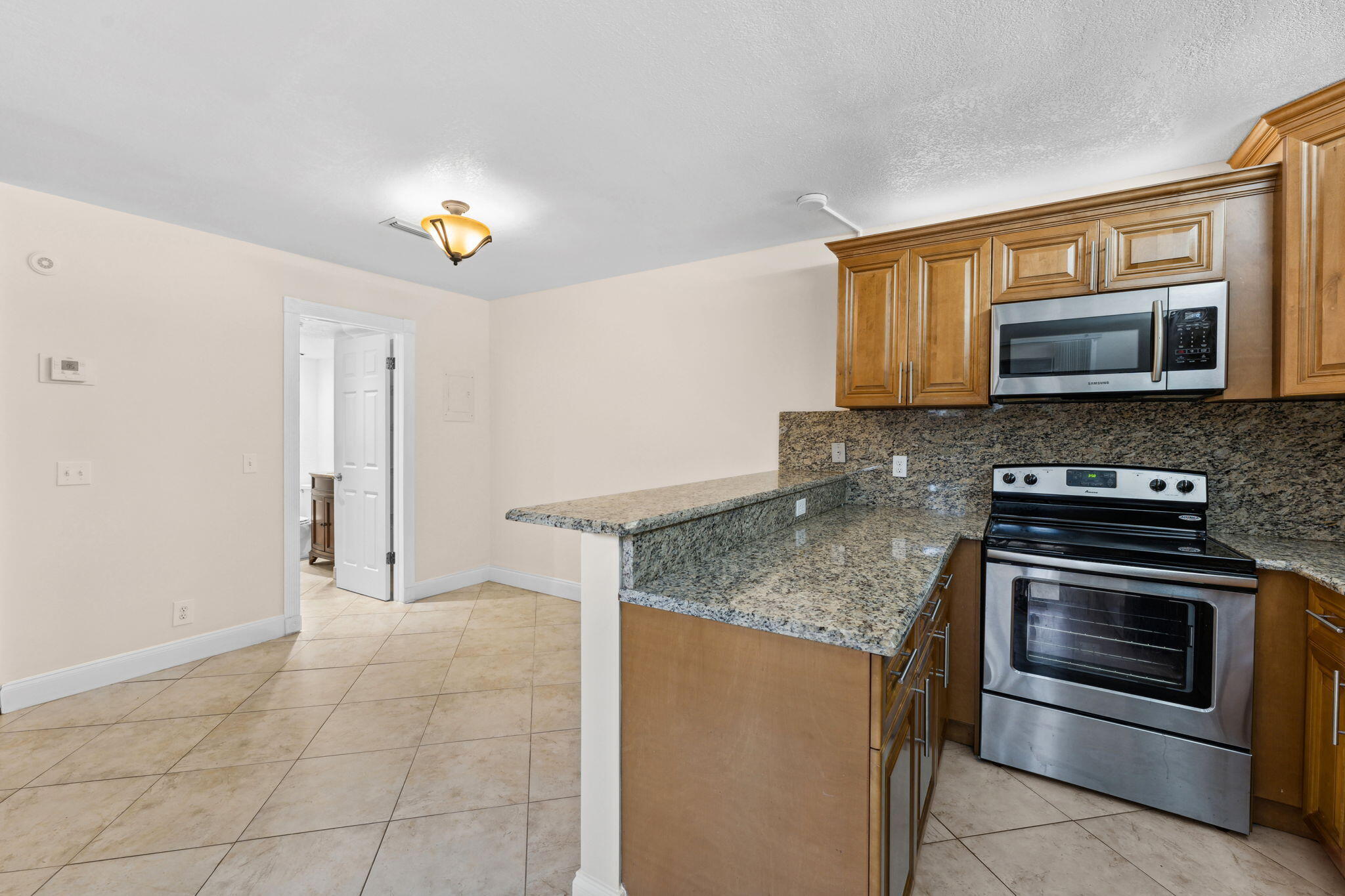 2438 Waterside Drive Lake Worth, FL 33461 - Photo 10 of 26 a kitchen with stainless steel appliances granite countertop a stove microwave and refrigerator