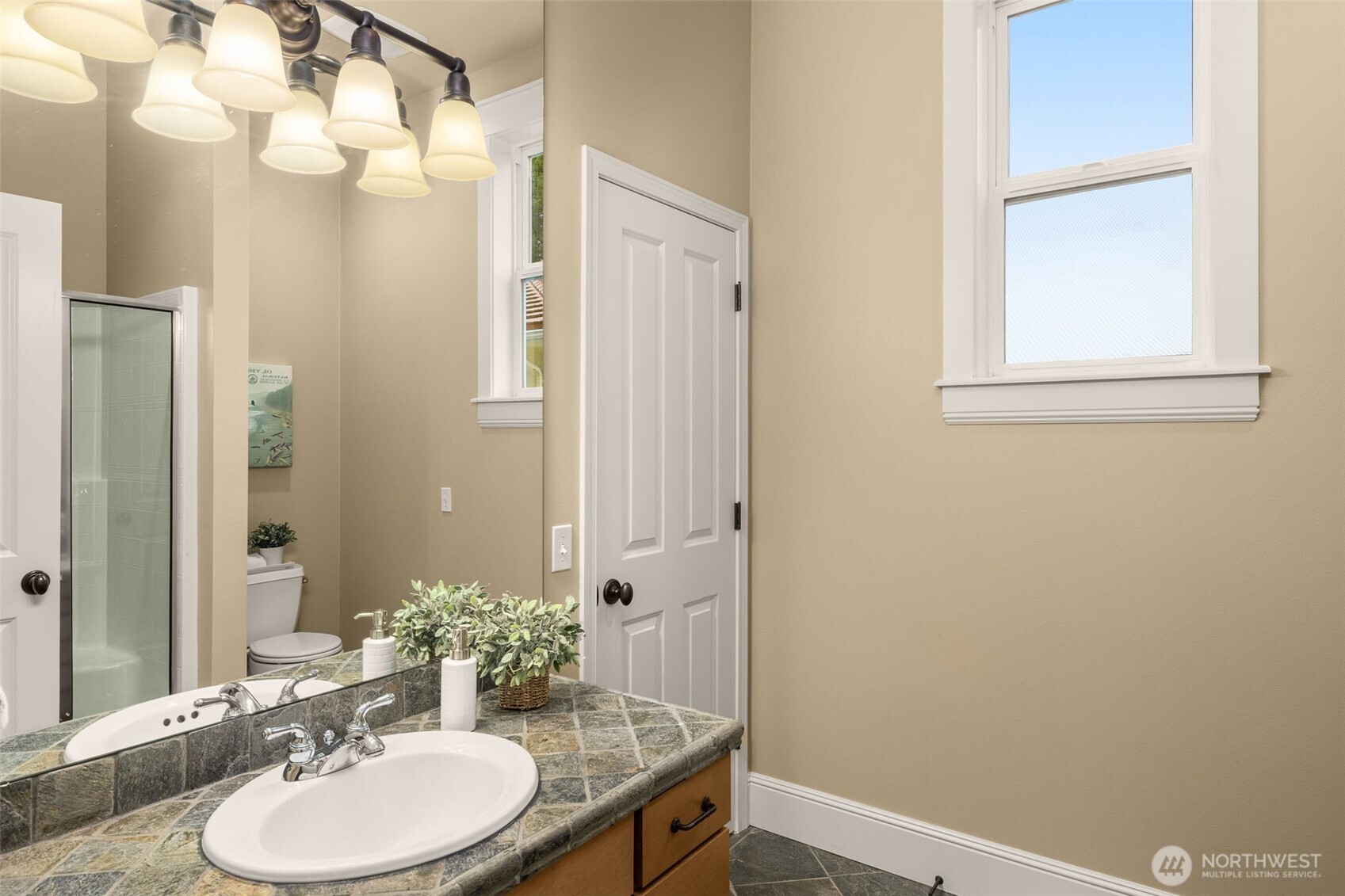 8360 Loyal Way Northwest Seattle, WA 98117 - Photo 13 of 36 a bathroom with a sink a mirror and a toilet