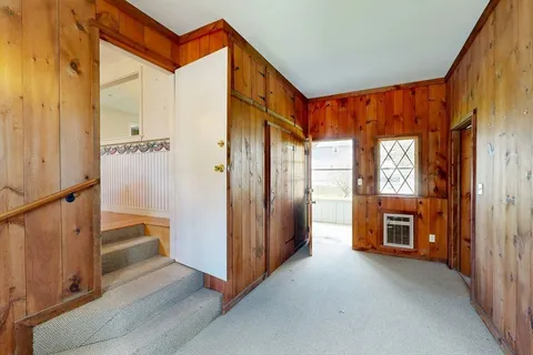 a view of a hallway with furniture and a window