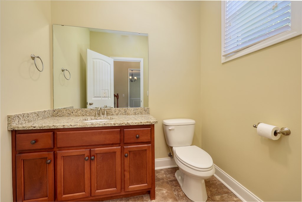 182 Oak Ridge Drive Waverly Hall, GA 31831 - Photo 44 of 52 a bathroom with a granite countertop toilet sink and mirror