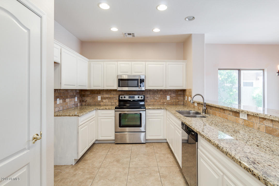 4559 West Cottontail Road Phoenix, AZ 85086 - Photo 3 of 23 a kitchen with a sink stove top oven and cabinets
