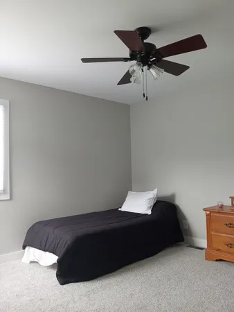 a bedroom with a bed and a ceiling fan