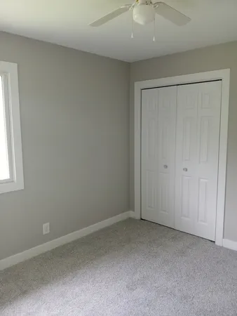 an empty room with a window and closet