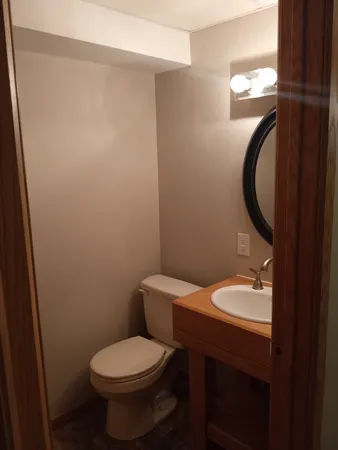a bathroom with a granite countertop toilet a sink and a mirror