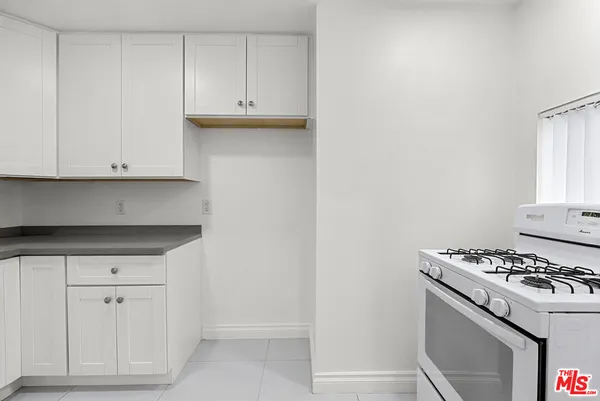 a kitchen with white cabinets and a stove