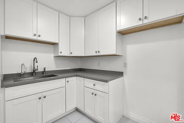 a kitchen with granite countertop white cabinets and a sink