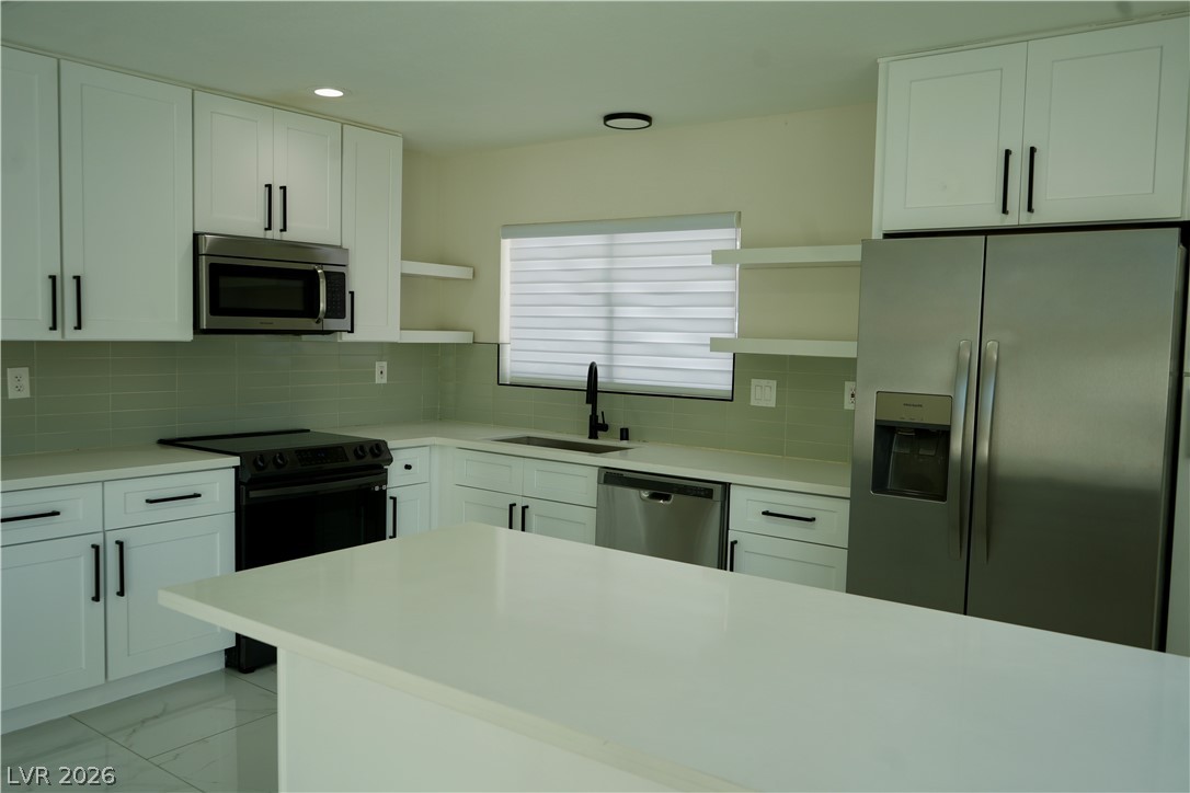 2351 Valleywood Road Henderson, NV 89014 - Photo 12 of 43 Kitchen with stainless steel appliances, white cabinets, open shelves, backsplash, and recessed lighting