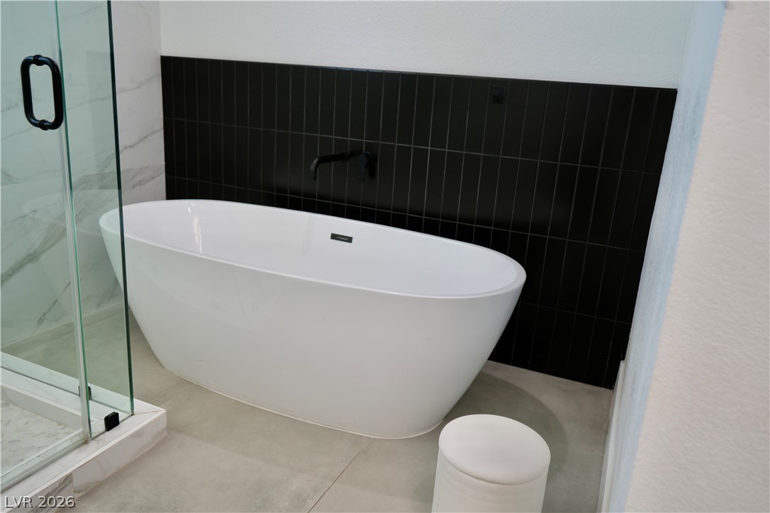 2351 Valleywood Road Henderson, NV 89014 - Photo 16 of 43 Full bathroom featuring a marble finish shower, a freestanding tub, and tile walls