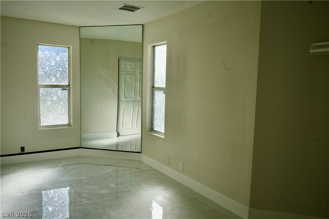 2351 Valleywood Road Henderson, NV 89014 - Photo 19 of 43 Empty room with light marble finish floors and baseboards