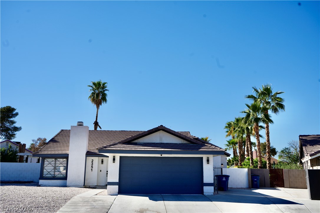 2351 Valleywood Road Henderson, NV 89014 - Photo 2 of 43 View of front of house with an attached garage, driveway, a tiled roof, and stucco siding