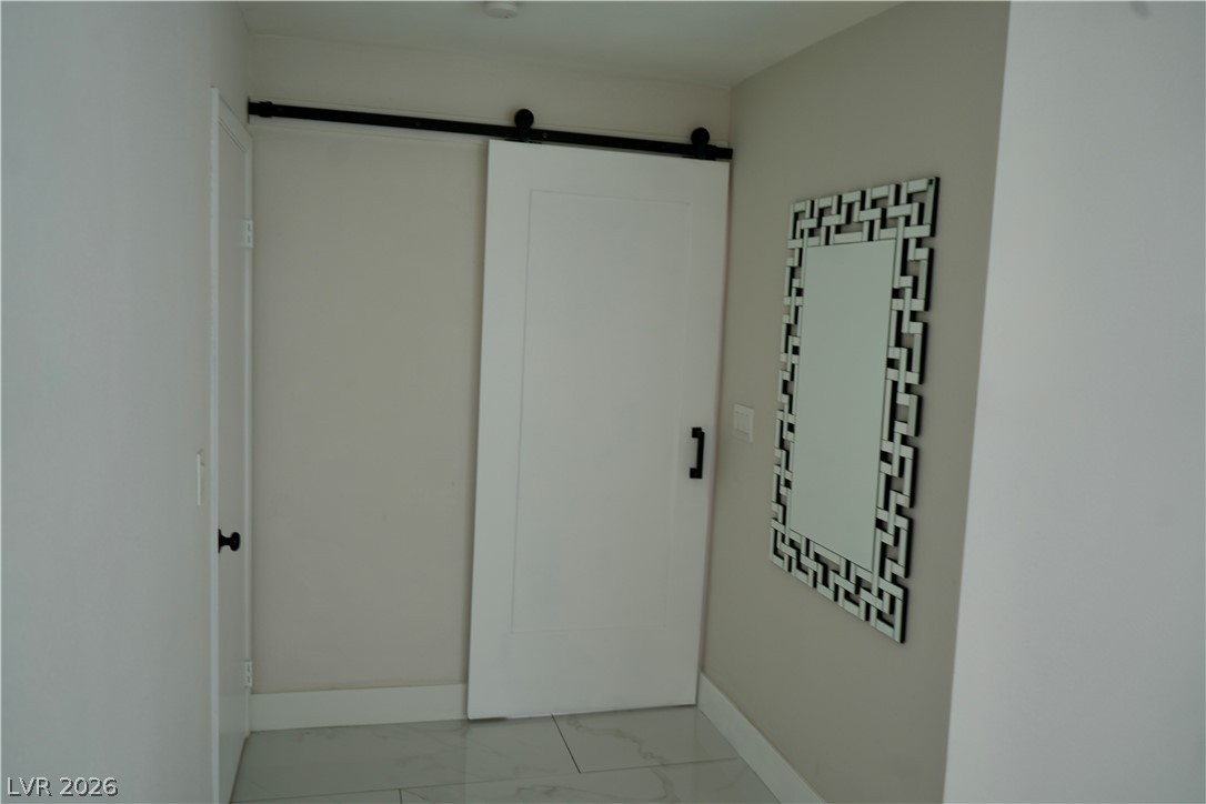 2351 Valleywood Road Henderson, NV 89014 - Photo 21 of 43 Corridor featuring a barn door and light marble finish floors