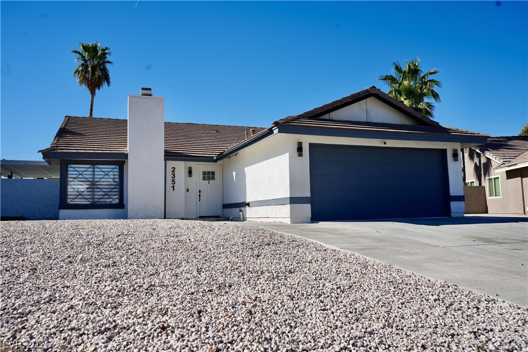 2351 Valleywood Road Henderson, NV 89014 - Photo 3 of 43 Single story home featuring a tiled roof, a chimney, a garage, concrete driveway, and stucco siding