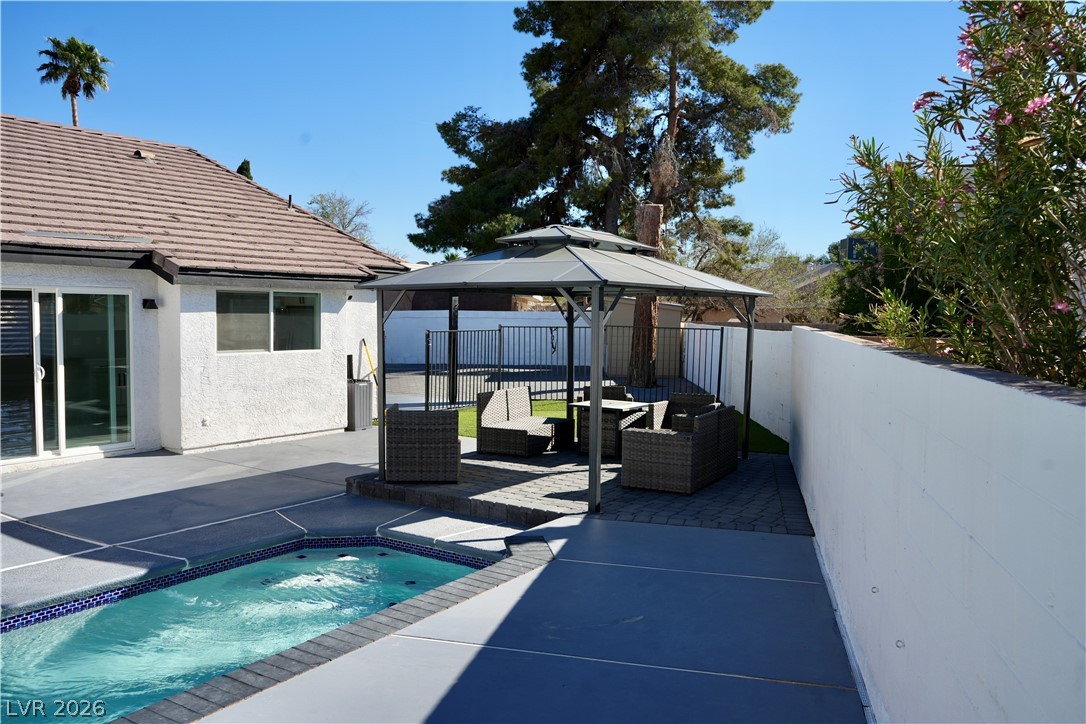 2351 Valleywood Road Henderson, NV 89014 - Photo 32 of 43 View of swimming pool with a gazebo, patio surround, a fenced backyard, an outdoor living space, and a hot tub