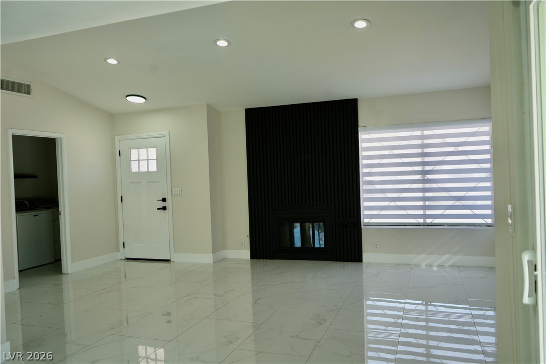 2351 Valleywood Road Henderson, NV 89014 - Photo 6 of 43 Entryway featuring light marble finish floors, recessed lighting, lofted ceiling, and washer / dryer