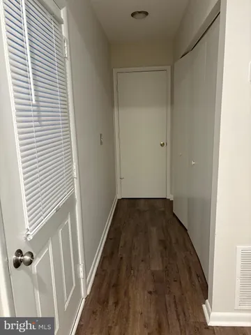 a view of a room with wooden floor and a window