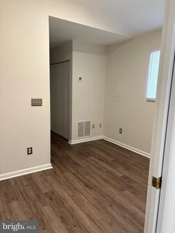 an empty room with wooden floor and closet