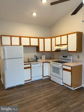 a kitchen with granite countertop a stove a sink and a refrigerator
