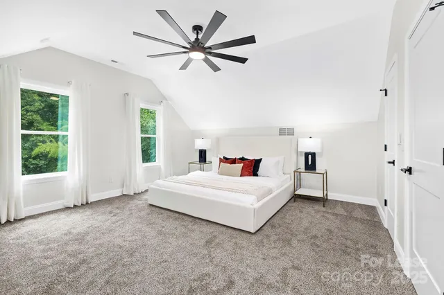 a spacious bedroom with a large bed and a chandelier
