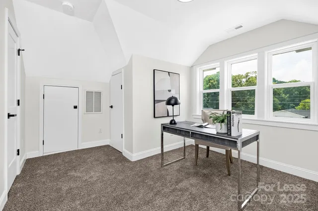 a view of a workspace with furniture and a window