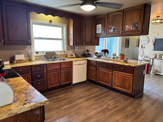 a kitchen with stainless steel appliances granite countertop a sink a stove a counter space and cabinets