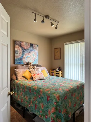 a bed sitting in a bedroom next to a window