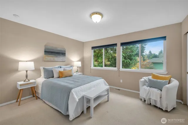 a spacious bedroom with a bed and lamp