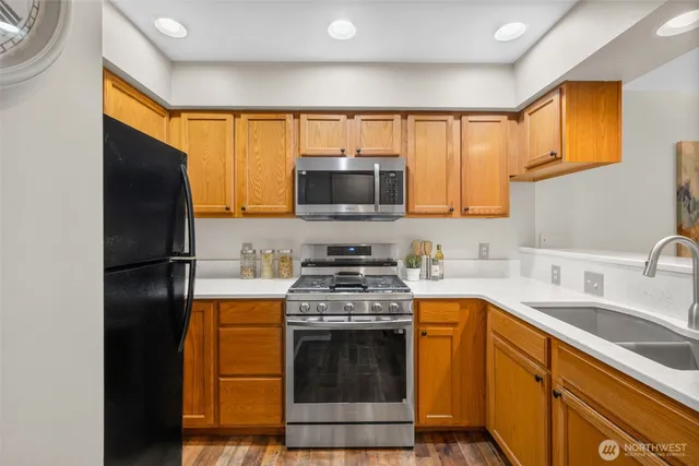 a kitchen with stainless steel appliances granite countertop a stove refrigerator sink and cabinets