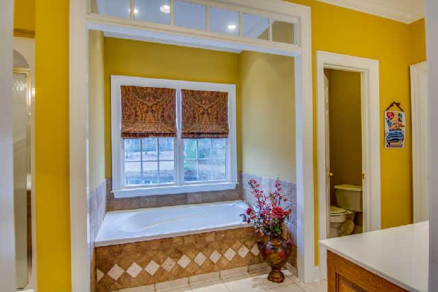 112 Revilo Road Leoma, TN 38468 - Photo 11 of 20 Master bathroom features a jetted tub, separate shower, his and her walk-in closets, and double vanity. Delight yourself with a view of the pond and nature while taking a relaxing bath.