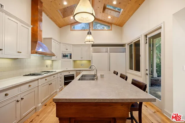 a kitchen with a stove a sink and a window