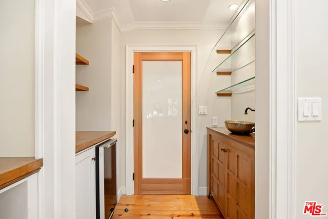 a front view of a building with a garden and trees