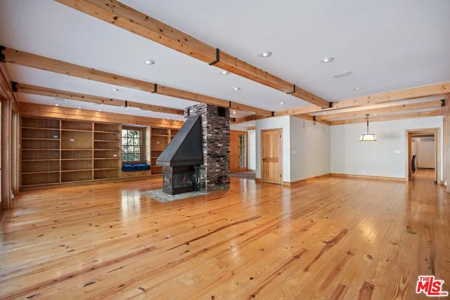 a view of empty room with wooden floor and fireplace