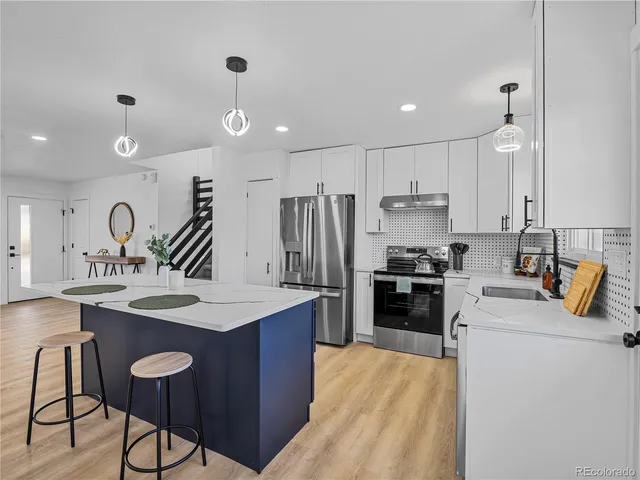 a kitchen with a stove a sink and a refrigerator