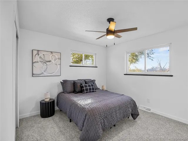 a bedroom with a large bed and a chandelier
