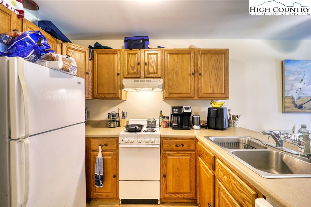128 Zeb Street, Unit A106 Boone, NC 28607 - Photo 9 of 22 a kitchen with a sink a refrigerator and cabinets
