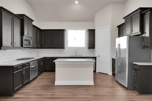 a kitchen with stainless steel appliances granite countertop a stove a refrigerator and a microwave