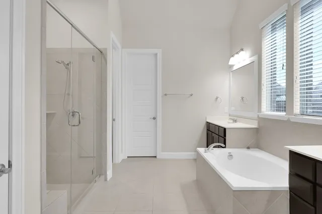 a bathroom with a tub a sink and a window