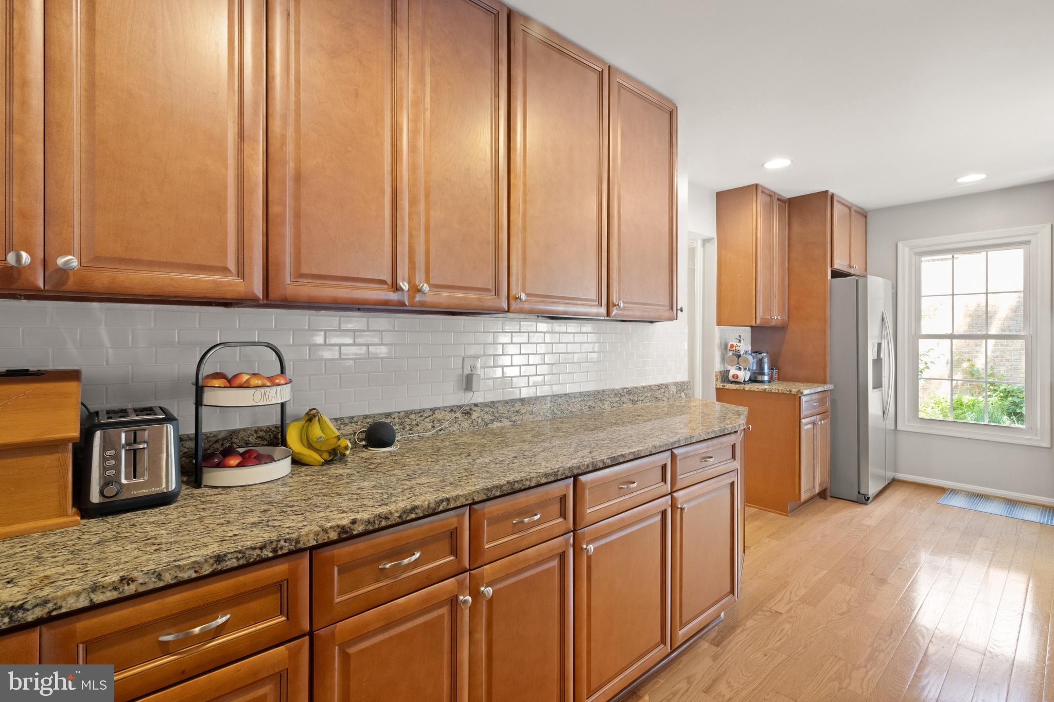 8573 Tyrolean Way Springfield, VA 22153 - Photo 11 of 32 a kitchen with stainless steel appliances granite countertop a sink a stove and a wooden cabinets