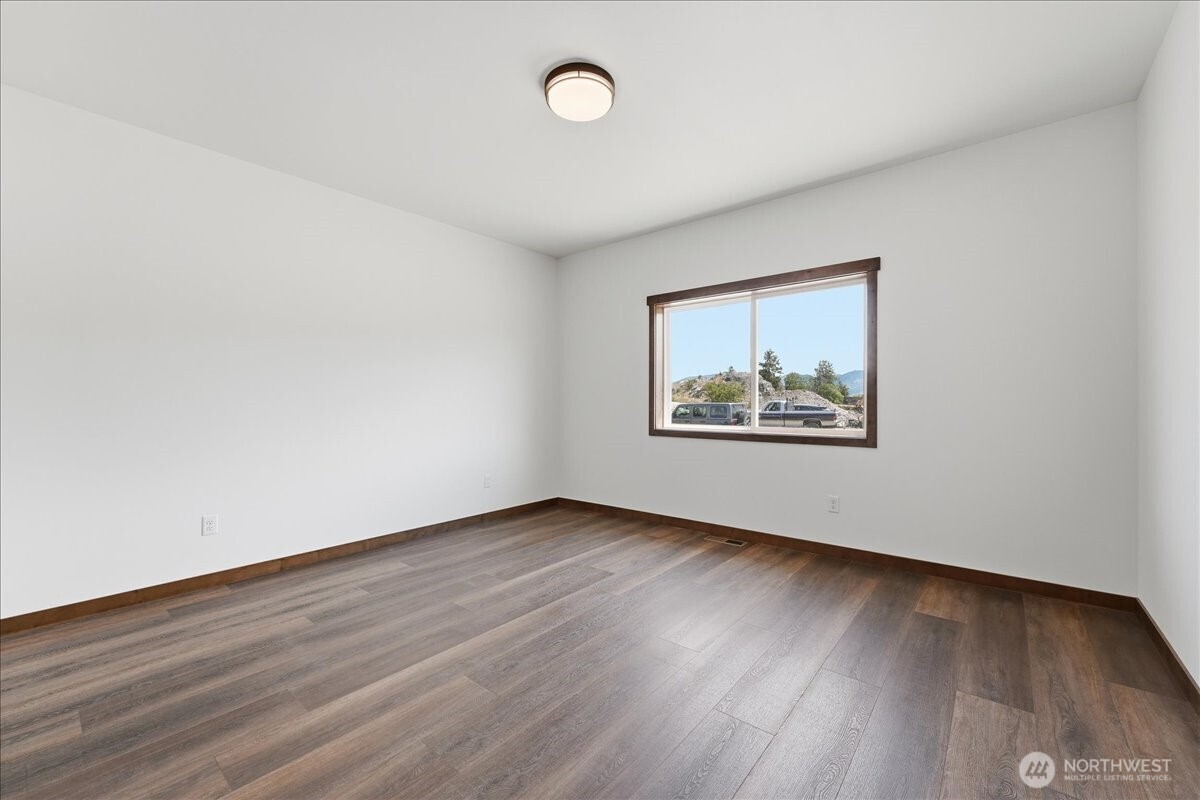 110 Slide View Lane Manson, WA 98831 - Photo 32 of 38 an empty room with wooden floor and window
